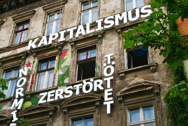 Altes Mietshaus mit Kapitalismuskritik